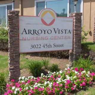 The entrance sign for Arroyo Vista, surrounded by colorful flowers.