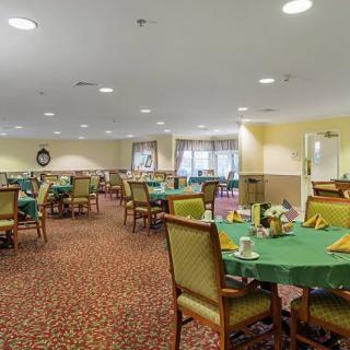 An indoor dining room with tables and chairs set for a meal.