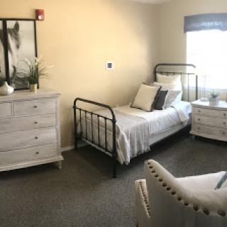 A cozy and inviting bedroom featuring a single bed, stylish furniture, and soft neutral tones.