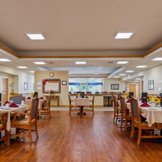 A spacious and elegantly decorated dining area with neatly arranged tables and chairs.