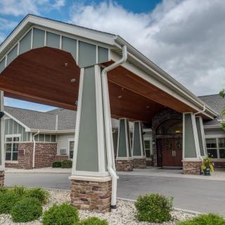 A modern building entrance with a covered walkway and landscaped surroundings.