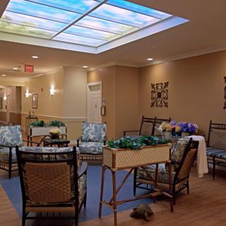 A cozy indoor seating area with comfortable chairs and decorative elements under a bright ceiling light panel.
