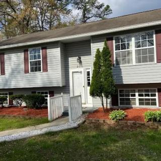 A charming split-level house with a welcoming front yard and neatly landscaped garden.