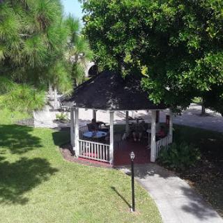 A peaceful gazebo surrounded by lush greenery in a serene park setting.