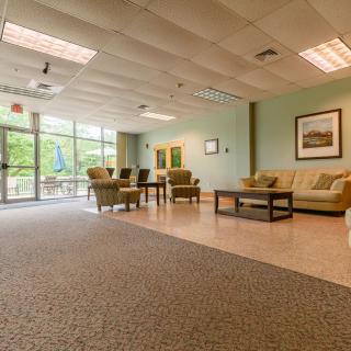 A spacious and well-lit lobby with comfortable seating and large windows.