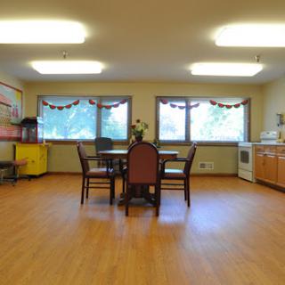A spacious and well-lit kitchen/dining area featuring a round table and chairs.