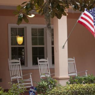 A cozy porch with rocking chairs and an American flag.