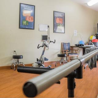 A physical therapy room equipped with exercise machines and rehabilitation tools.