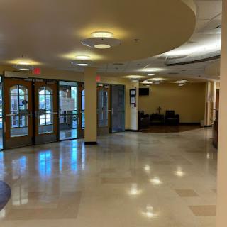 A spacious lobby area featuring large glass doors and contemporary lighting.