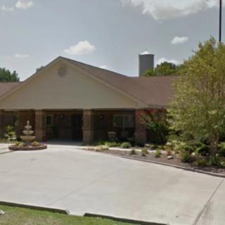 A suburban residential building with a landscaped driveway and garden.