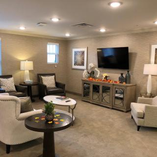 A modern and cozy living room with comfortable seating, a large TV, and elegant lighting.