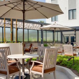 A charming outdoor patio area with tables, chairs, and umbrellas for relaxation.
