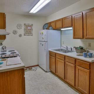 A cozy kitchen with wooden cabinets and essential appliances.