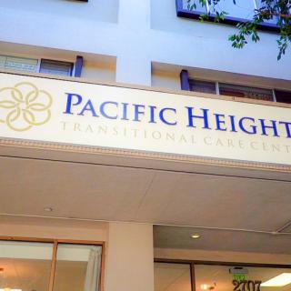 A sign for Pacific Heights Transitions Healthcare facility on a building facade.