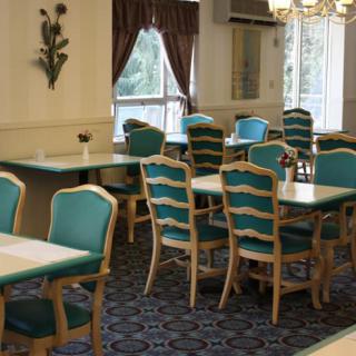 A cozy dining room with neatly arranged tables and chairs, featuring elegant decor.