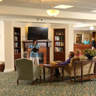 A cozy lounge area where a speaker presents to an audience in a comfortable setting.