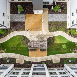 Aerial view of a modern courtyard with landscaped pathways and green spaces between buildings.