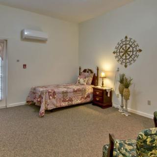 A cozy bedroom with a single bed, nightstand, and decorative wall art.