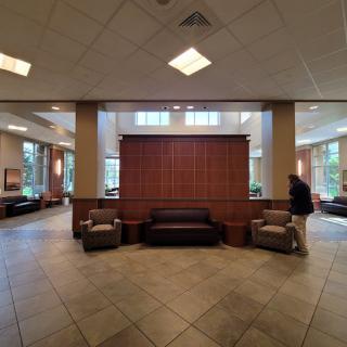 A spacious lobby area with seating arrangements and large windows.