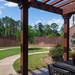 A beautifully landscaped backyard with a pergola and patio area.