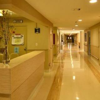 A clean and well-lit hospital hallway with a reception area.