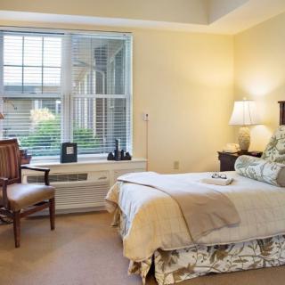 A cozy bedroom with elegant decor and a large window.