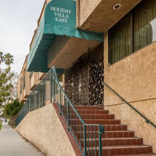 Entrance of a building with an awning and stairs leading up.