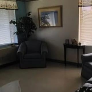 A cozy living room with a chair, sofa, table, and decorative elements.
