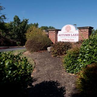 Entrance sign for Autumn Lakes surrounded by landscaping and greenery.