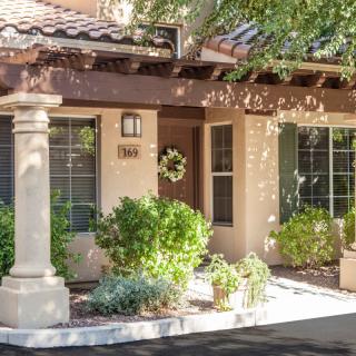 A cozy house exterior surrounded by greenery and a welcoming entrance.
