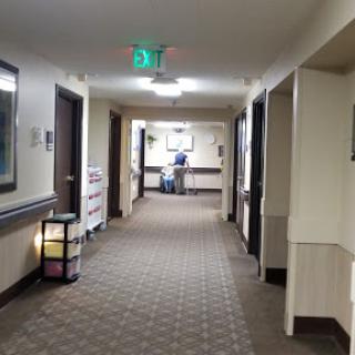 A view down a well-lit corridor in a healthcare facility, featuring doors on either side.