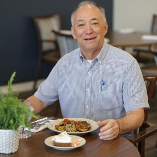 A man enjoying a meal at a restaurant table.