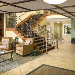 A spacious lobby with comfortable seating and a staircase leading to the upper level.