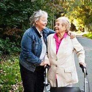 Two elderly women enjoying a walk together in the park.