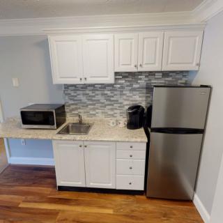 Compact kitchen setup with modern appliances and stylish backsplash.