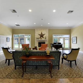 A spacious and elegantly decorated living room featuring a central fireplace.