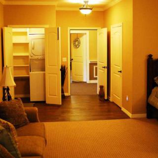 A cozy bedroom with an open closet and warm lighting.