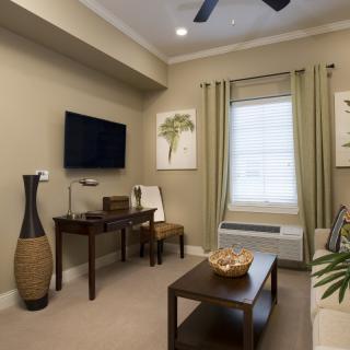 A modern living room with a television, artwork, and stylish furniture.