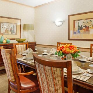 A well-decorated dining room with a set table and floral centerpiece.