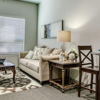 A cozy living room with modern decor, featuring a comfortable sofa, a side table with a lamp, and stylish furnishings.