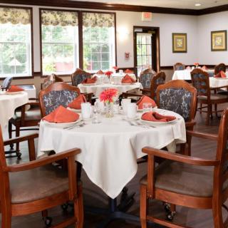 An elegantly arranged dining room with neatly set tables and chairs, ready for guests.