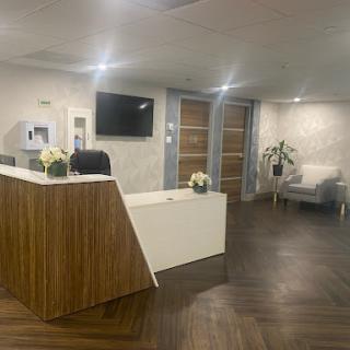 A modern office reception area featuring a sleek front desk, comfortable seating, and stylish decor.