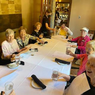 A cheerful gathering of seniors enjoying a meal together at a restaurant.
