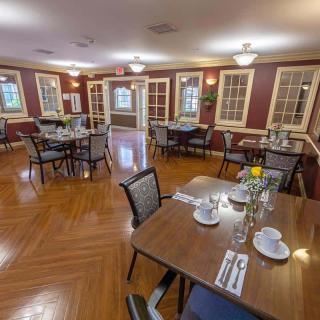 An elegant dining room with neatly set tables and comfortable seating.