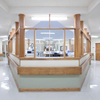 A modern hospital reception area featuring wooden accents and a clean, spacious layout.