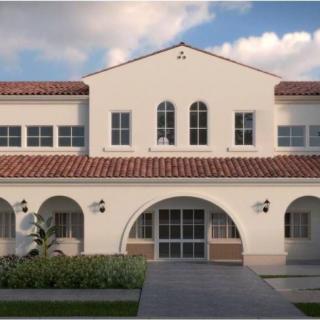 A Spanish Colonial style building with arched windows and red roof tiles.
