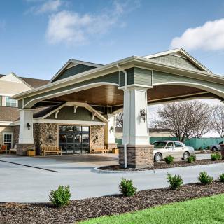 The entrance of a hotel showcasing its architectural design and landscaped surroundings.