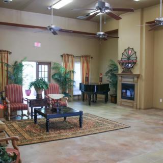 A spacious living room featuring comfortable seating, a grand piano, and a cozy fireplace.