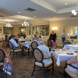 A social gathering at a dining venue, featuring several guests seated at tables.