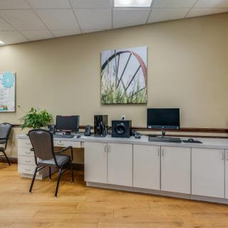 A modern office workspace featuring desks with computers and decorative wall art.